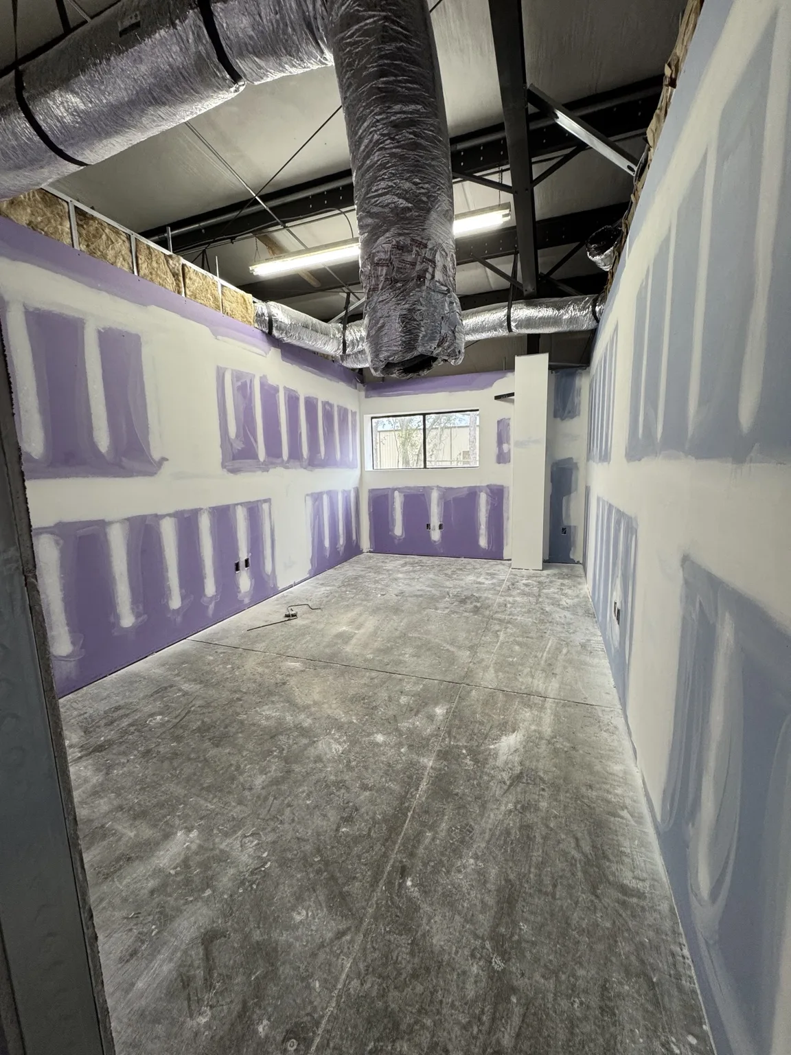 Commercial space with drywall joints being finished